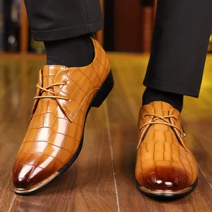Classic light brown men's oxford shoes with crocodile texture on warm wooden floor