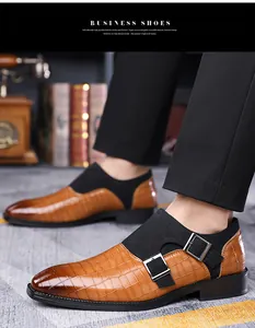 Close-up of brown crocodile embossed leather monk strap shoes with silver buckles