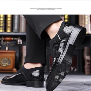 Close-up of black crocodile embossed monk strap leather shoes in a library setting