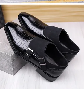 Detail view of black double monk strap shoes with textured leather and metal buckles