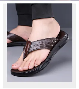 Close-up of men's leather flip-flops with brown crocodile texture and cushioned black sole