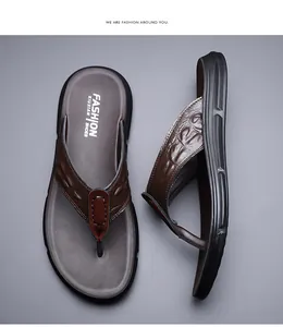 Detailed close-up of men's leather flip flops featuring brown crocodile pattern straps