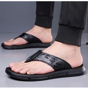 Close-up of black leather flip-flops for men with realistic crocodile texture on straps