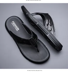 Detail of men's leather flip flops featuring black crocodile texture and non-slip sole