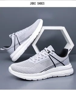 Détail de chaussures de course en mesh gris clair avec tissu respirant et semelles blanches