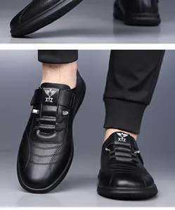 Détail de la chaussure en cuir noir avec logo XTZ et motif ailes sur la languette
