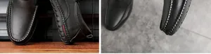 Detalle de mocasines de cuero granulado negro con costuras blancas y suela de diseño moda