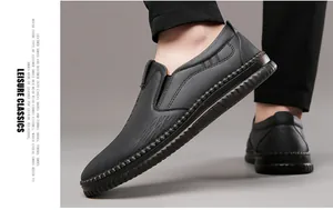 Close-up of black leather slip-on loafers showing thick non-slip rubber soles and stitching