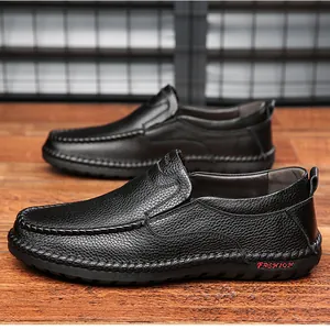 Primer plano de mocasines de cuero negro con detalle de letras rojas decorativas