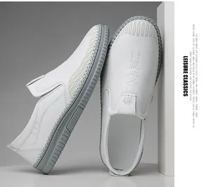 Detail view of white leather loafers with thick gray rubber soles and side stitching