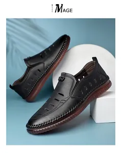 Detail of black hollowed leather summer sandals with breathable holes and brown rubber sole