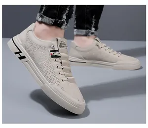 Détail macro du cuir perforé respirant et ruban tricolore sur la chaussure de sport beige
