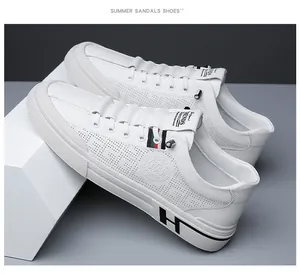 Détail de baskets blanches pour hommes avec perforations et bande rayée vert et rouge