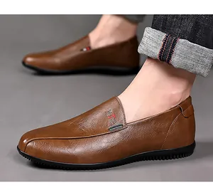 Detail of men's brown leather loafers showing metal buckle and side non-slip sole texture