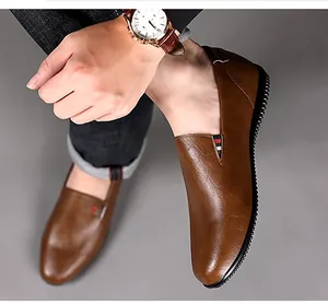 Detail of brown leather slip-on loafers with side ribbon detail and rubber soles