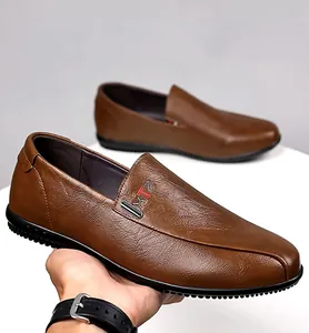 Detail of men's brown leather loafers showing XTZ logo, stitching, and non-slip rubber sole