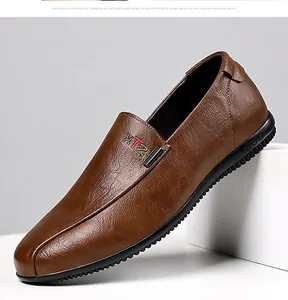 Macro detail of brown textured leather loafers with XTZ logo and anti-slip rubber sole