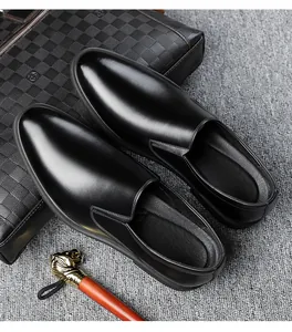 Close-up of polished black leather loafers next to a stylish checkered business handbag