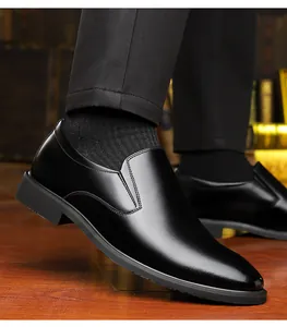 Close-up of premium black leather dress shoes with side stitching on a wooden floor