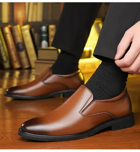 Detail of men's brown loafers with hand-burnished finish on a classic wooden floor