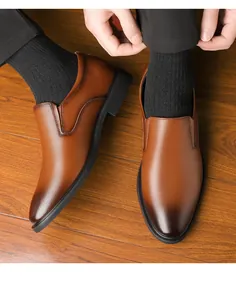 Vertical top view of men's brown gradient leather shoes on professional wooden background