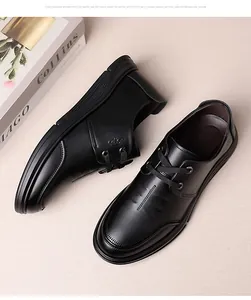 Overhead view of black leather lace-up men's shoes with rubber soles on a soft cloth