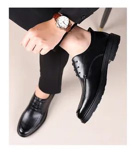 Overhead view of men's black leather derby shoes worn with tailored suit trousers