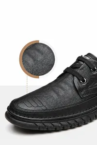 Détail de chaussures décontractées noires pour hommes avec texture cuir et semelle antidérapante