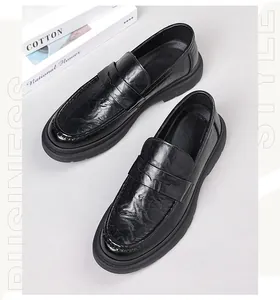 Detail view of black penny loafers with textured leather and thick rubber soles