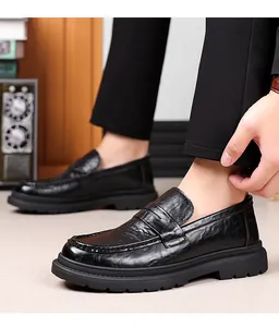 Close-up of black leather penny loafers with thick rubber soles and non-slip treads
