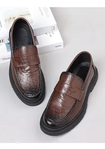 Detail of dark brown leather penny loafers with vintage burnished finish and rubber soles