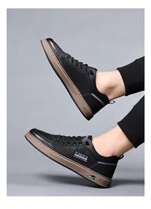 Detail of men's black leather casual shoes featuring pebbled texture and thick gum soles