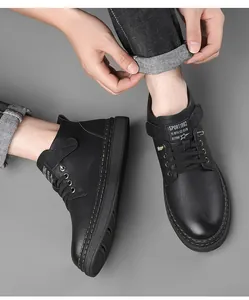 Detail of black leather boots with yellow stitching and Sport 1982 logo on the tongue
