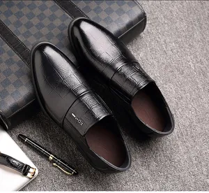 Detalle de zapato en cuero negro con textura de cocodrilo, hebilla metálica y estilo casual