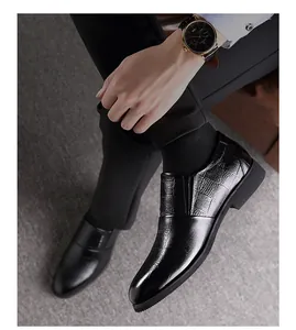Detalle de zapatos de negocios en cuero negro con textura de cocodrilo y suela de goma