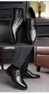 Vista detallada de mocasines de cuero negro con relieve de cocodrilo y hebilla metálica H
