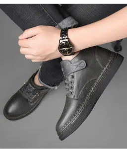 Detail of winter men's boots with side stitching and velcro ankle strap in charcoal gray