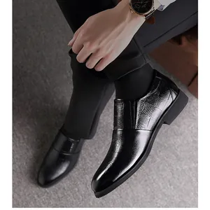 Mocasines de hombre en cuero negro con grabado de cocodrilo en un entorno formal de negocios