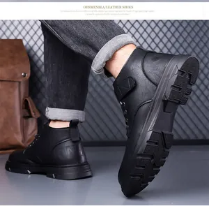 Detail view of black textured leather men's winter boots with thick non-slip rubber soles