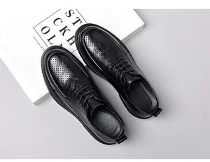 Detailaufnahme schwarzer Derby-Schuhe aus Leder mit Lochverzierung auf dicker Sohle