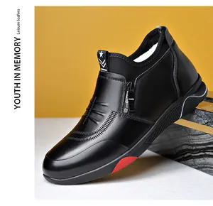 Detail of black men's snow boots featuring a side metal zipper and red rubber sole accent