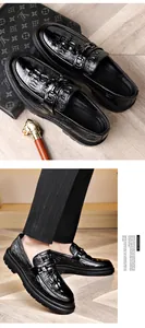 Detail of black crocodile embossed leather loafers with metal horsebit and thick lug sole