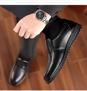 Vista dall'alto di scarpe slip-on in pelle nera con texture su pavimento in legno