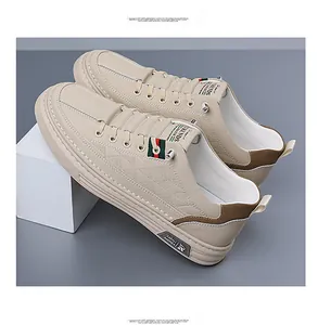 Detalle de zapatilla de cuero beige con relieve lateral y cinta de rayas roja y verde