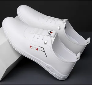 Detailed side view of white leather sneakers with XINTAI logo and textured rubber sole