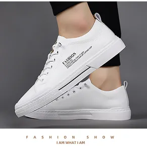 Detail van de witte lederen textuur en decoratieve tekst op de herensneaker