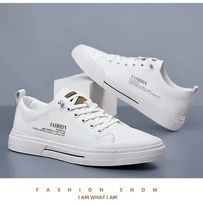 Detail van witte leren sneakers met tekst aan de zijkant en bruin label op de tong