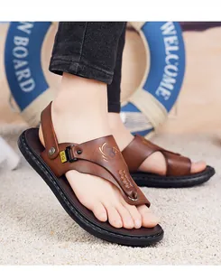 Detail van bruine leren heren slippers met verstelbare band en antislip dikke rubberen zool