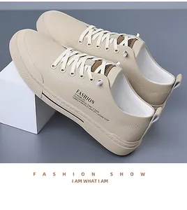 Gedetailleerd zicht op beige heren sneakers van zacht leer met stijlvolle tekstdetails