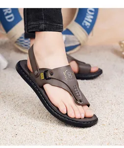 Detailopname van bruine herenslippers met antislip rubberen zool in een strandsetting